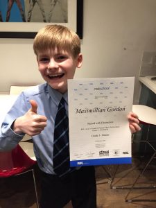 Boy with Rockschool exam certificate from drum lessons